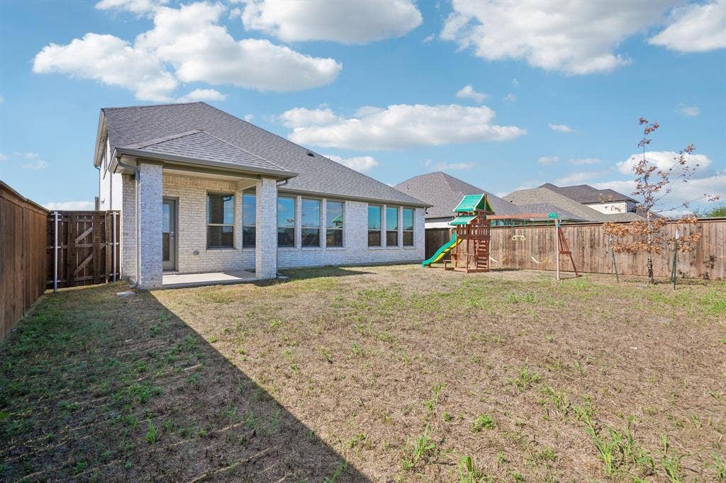 135 Lost Maples Way, Waxahachie, TX 75165 Brick exterior with a covered rear patio and wood privacy fencing