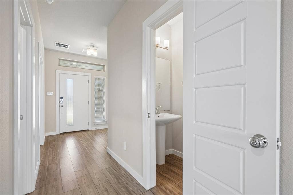 135 Lost Maples Way, Waxahachie, TX 75165 Entryway featuring wood-finish flooring, a white front door with sidelight, a transom window, and a pedestal sink