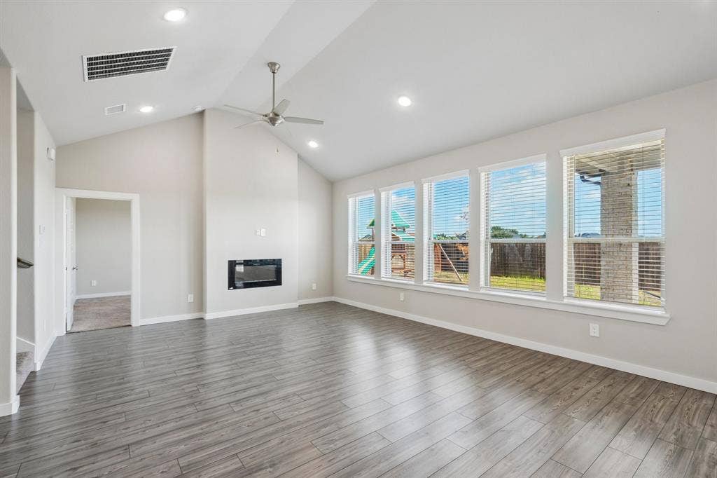 135 Lost Maples Way, Waxahachie, TX 75165 Vaulted ceilings, wood-finish flooring, built-in fireplace, recessed lighting, and expansive windows