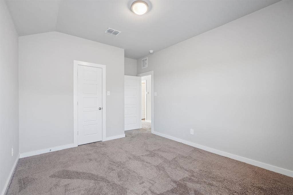135 Lost Maples Way, Waxahachie, TX 75165 Interior room featuring neutral-toned carpeting, high ceilings, flush-mount lighting, and four-panel interior doors