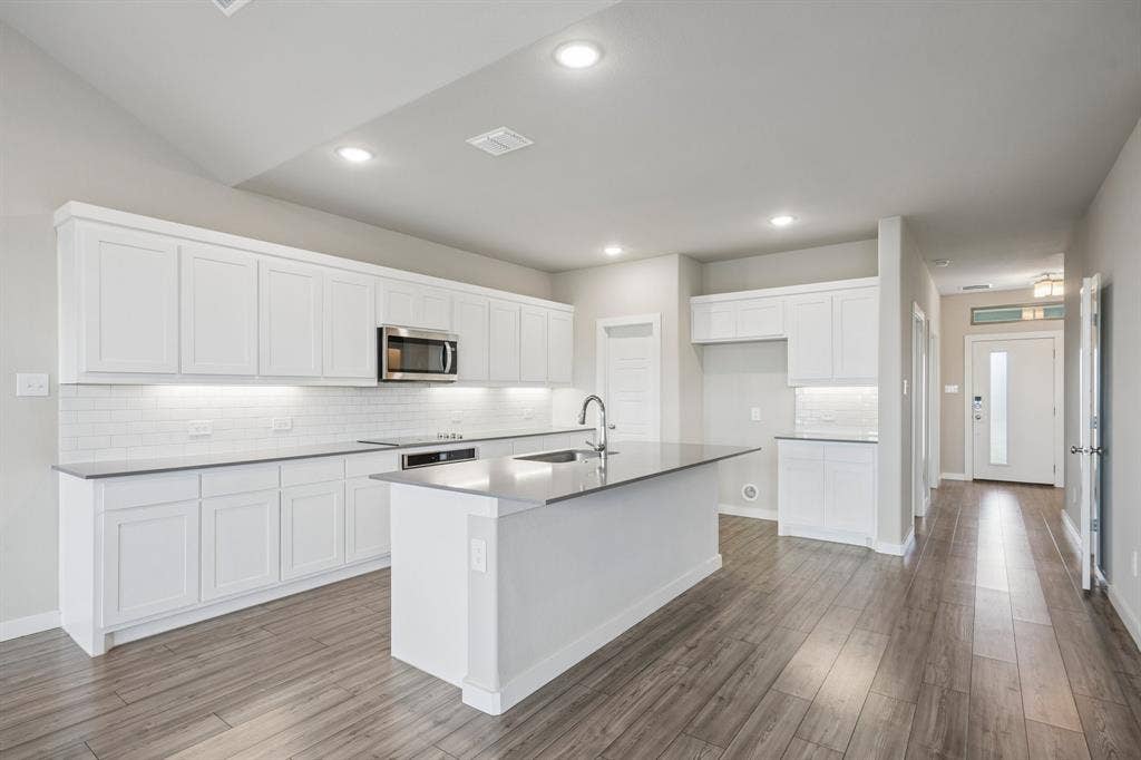 135 Lost Maples Way, Waxahachie, TX 75165 Kitchen featuring white cabinetry, solid-surface countertops, subway tile backsplash, recessed lighting, and wood-finish flooring