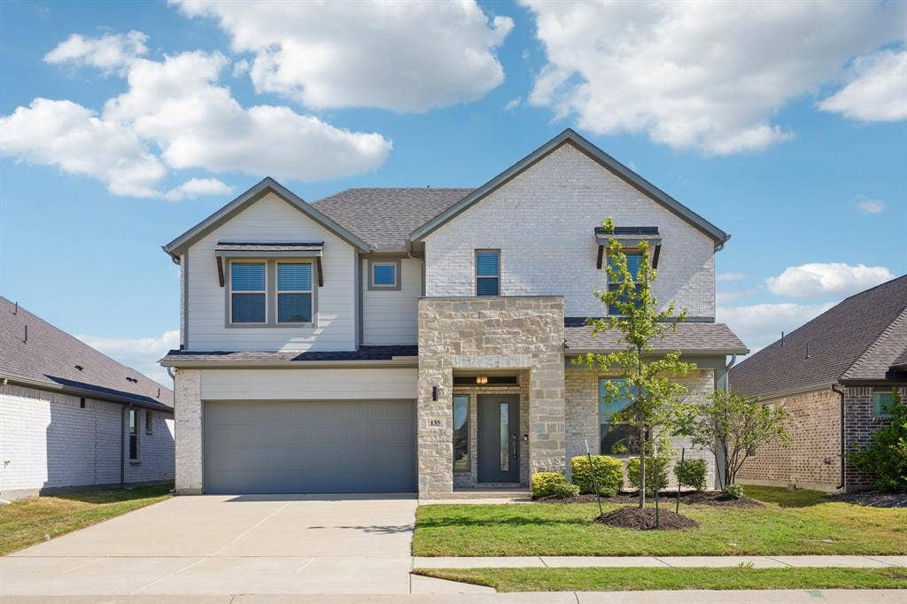 135 Lost Maples Way, Waxahachie, TX 75165 Two-story residence featuring a combination stone and brick facade, gabled roofline, covered entryway, and two-car attached garage