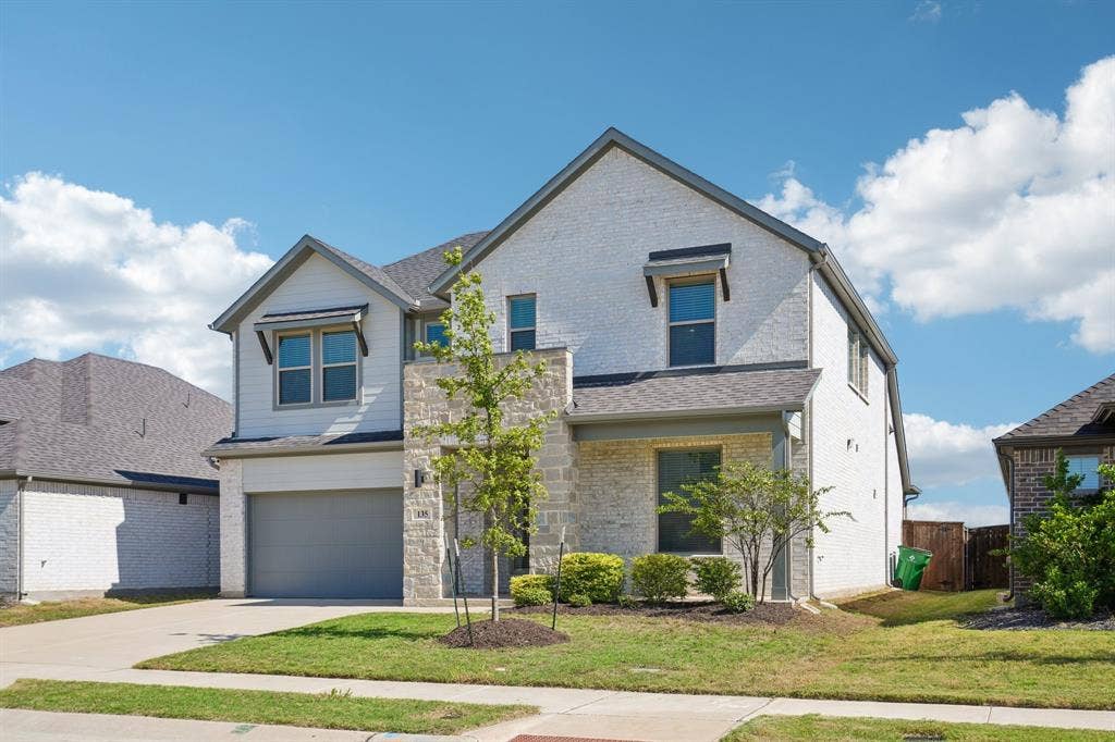 135 Lost Maples Way, Waxahachie, TX 75165 Two-story exterior featuring a brick and stone facade, gabled roofline, covered entryway, and attached garage
