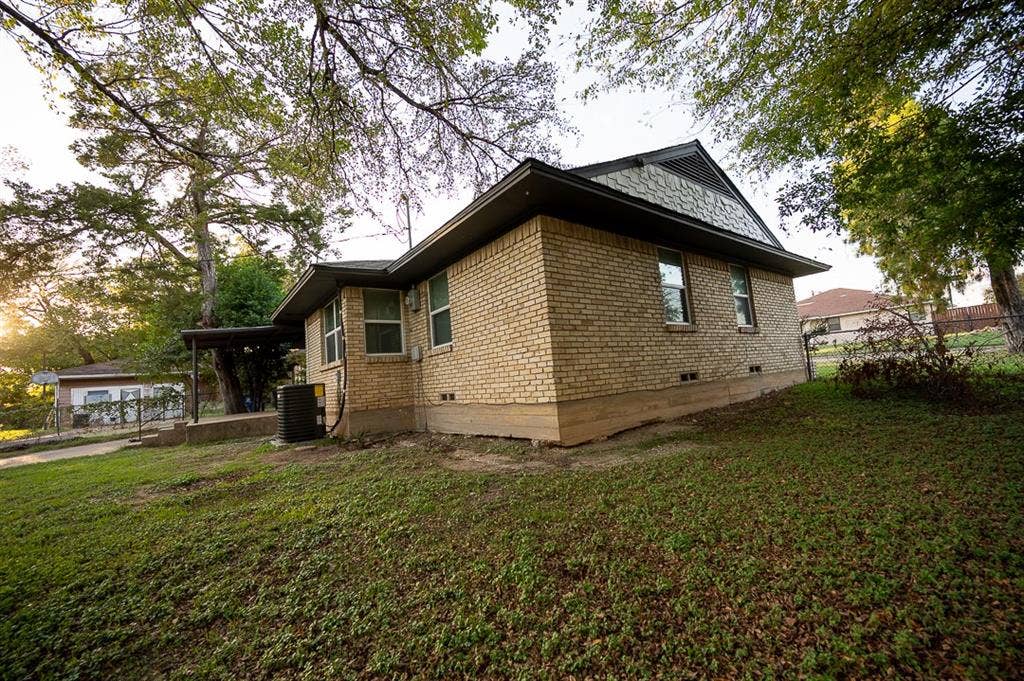 2406 Cliff Teen Court, Dallas, TX 75233 Exterior featuring a tan brick facade, gabled roofline with shingle accents, and a concrete foundation