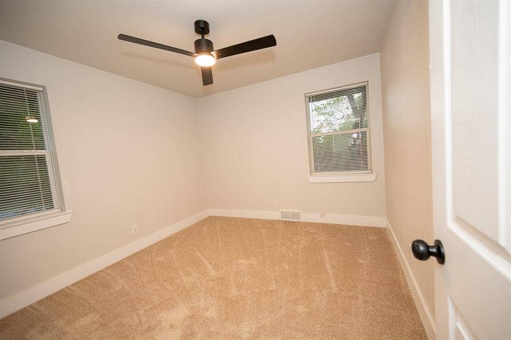 2406 Cliff Teen Court, Dallas, TX 75233 Neutral interior room featuring plush carpeting, a modern matte black ceiling fan with integrated lighting, and dual windows