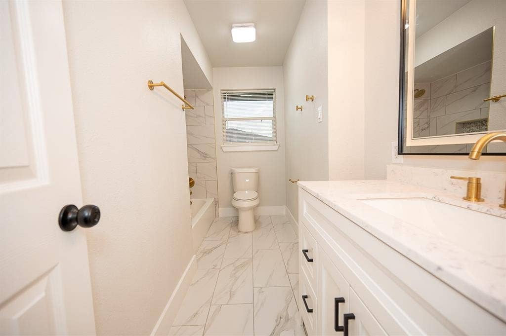 2406 Cliff Teen Court, Dallas, TX 75233 Bathroom featuring a vanity with a light-toned countertop, rectangular undermount sink, and brass-tone hardware