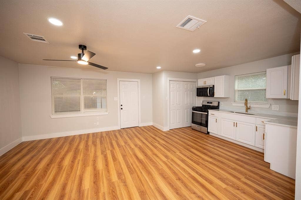 2406 Cliff Teen Court, Dallas, TX 75233 Wood-finish flooring, white shaker-style cabinetry, stainless steel kitchen appliances, recessed lighting, and a ceiling fan