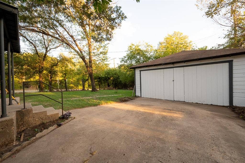 2406 Cliff Teen Court, Dallas, TX 75233 Detached two-car garage with white siding, concrete driveway, concrete stairs with metal railings, and mature trees