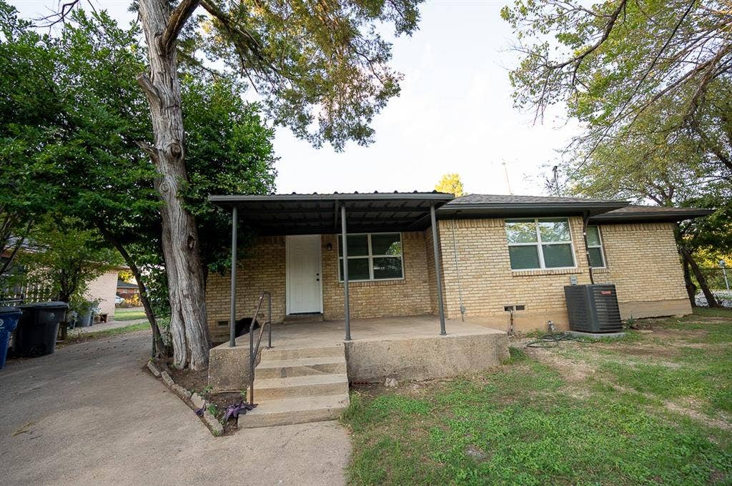 2406 Cliff Teen Court, Dallas, TX 75233 Exterior featuring a light brick facade, covered concrete front porch with metal supports, and mature trees