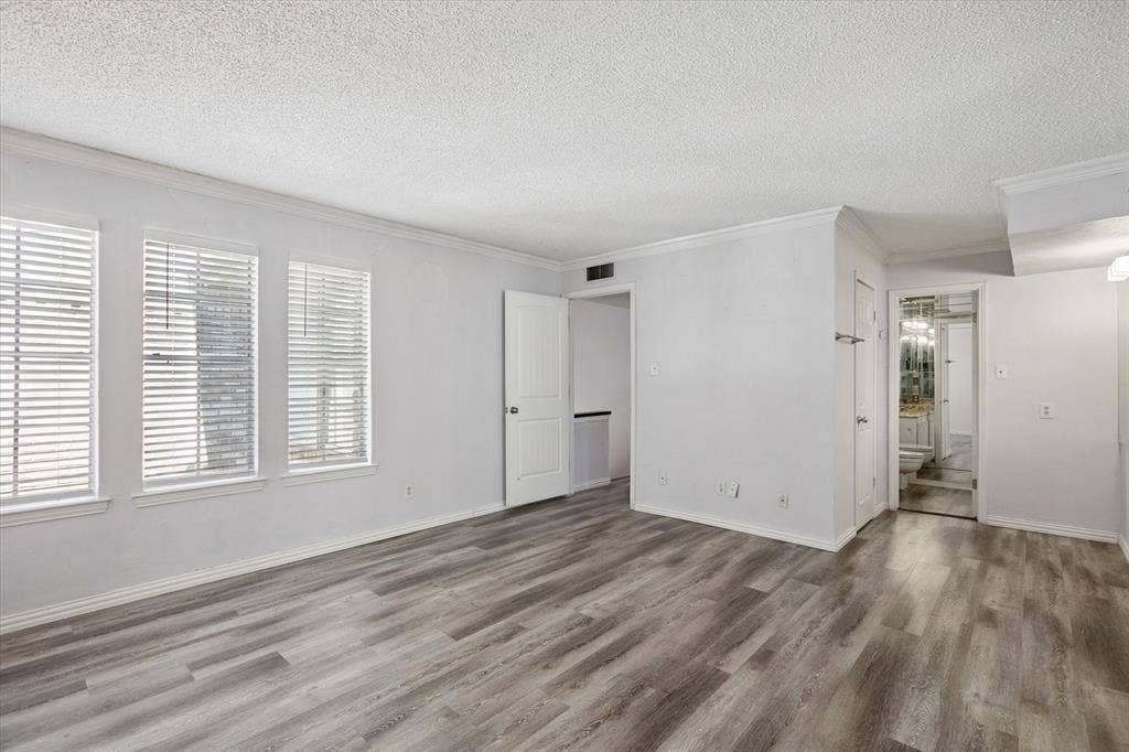 513 Towne House Lane, Richardson, TX 75081 Neutral-toned interior featuring wood-finish flooring, crown molding, and windows fitted with white blinds