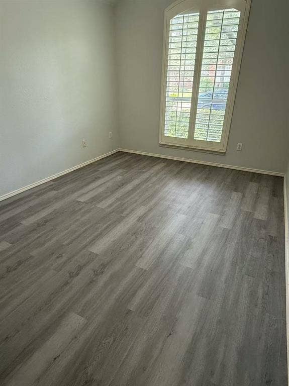 1307 Capstan Drive, Allen, TX 75013 Neutral-toned interior space featuring wood-finish flooring, an arched window, and custom interior shutters