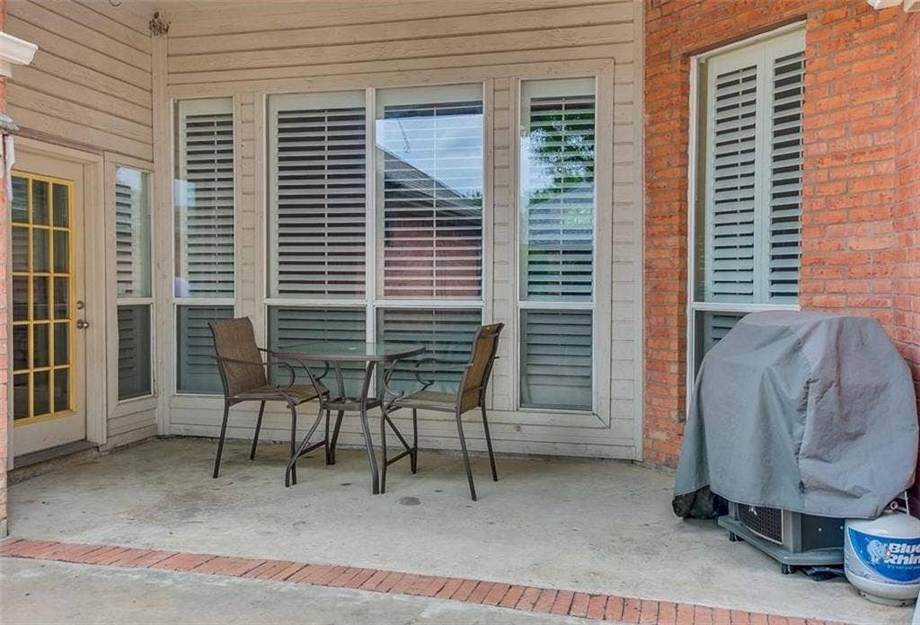 1307 Capstan Drive, Allen, TX 75013 Covered patio featuring a concrete floor with brick border detailing, brick and siding exterior, and multi-pane windows equipped with interior shutters
