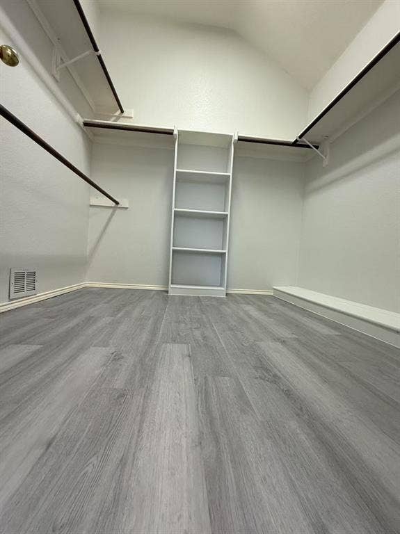 1307 Capstan Drive, Allen, TX 75013 Walk-in closet featuring wood-finish flooring, built-in shelving, and dual-level hanging rods