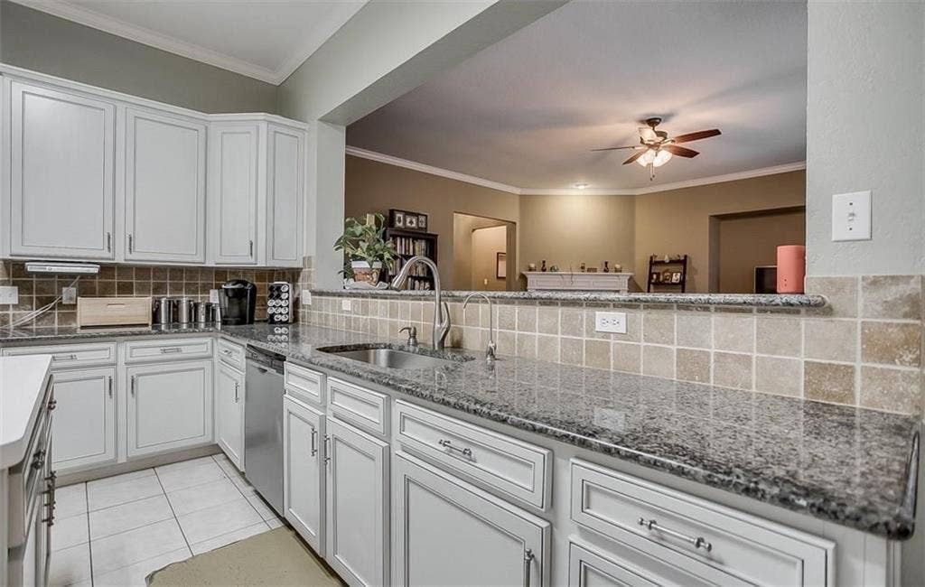 1307 Capstan Drive, Allen, TX 75013 Kitchen featuring white cabinetry, stone countertops, square-tile backsplash, stainless steel sink, and stainless steel dishwasher