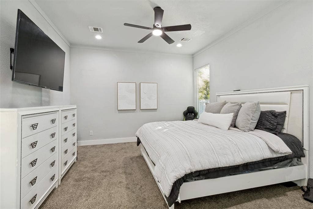 7909 Ivory Lane, Dallas, TX 75216 Neutral-toned interior featuring plush carpeting, crown molding, recessed lighting, and a modern ceiling fan