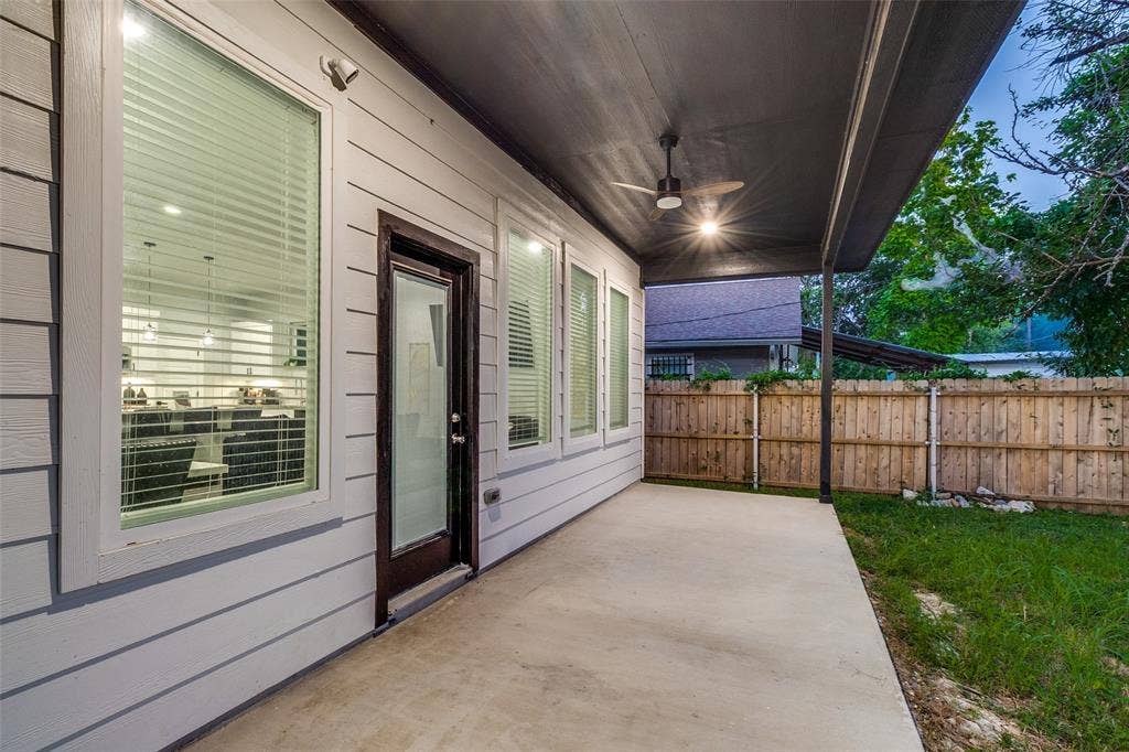 7909 Ivory Lane, Dallas, TX 75216 Covered back patio with a concrete floor, horizontal lap siding, integrated ceiling fan, and access via a full-lite exterior door