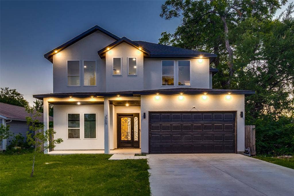 7909 Ivory Lane, Dallas, TX 75216 Two-story stucco exterior featuring a covered front porch, an ornamental glass-paneled entry door, a multi-car garage, and double-hung windows