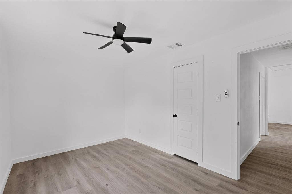 1831 Highland Street, Mesquite, TX 75149 Interior space featuring wood-finish flooring, a five-panel interior door, and a matte black ceiling fan with integrated lighting