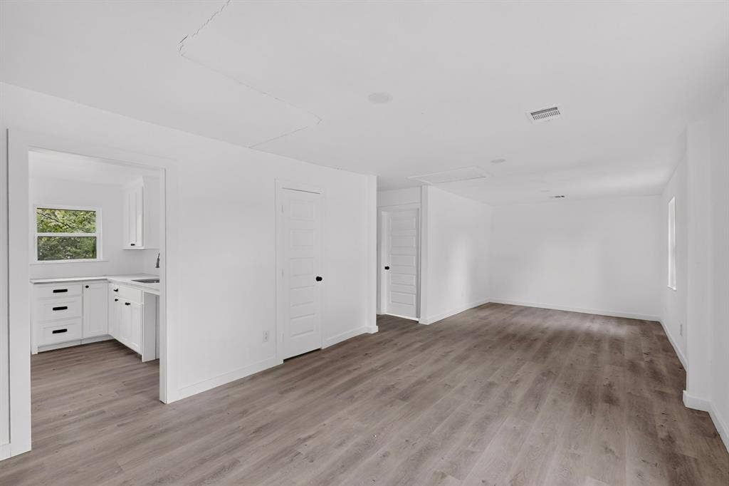 1831 Highland Street, Mesquite, TX 75149 Interior space featuring wood-finish flooring, white shaker-style cabinetry, matte black hardware, and multi-panel interior doors