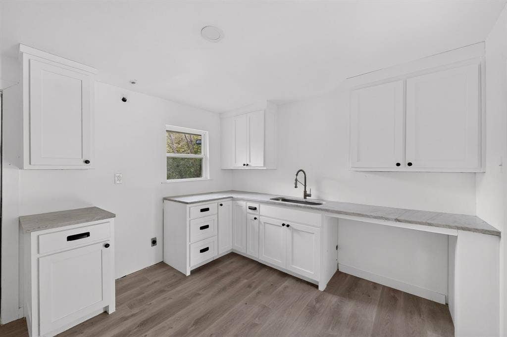 1831 Highland Street, Mesquite, TX 75149 Kitchen featuring white cabinetry, stone-finish countertops, wood-finish flooring, undermount sink, and matte black hardware