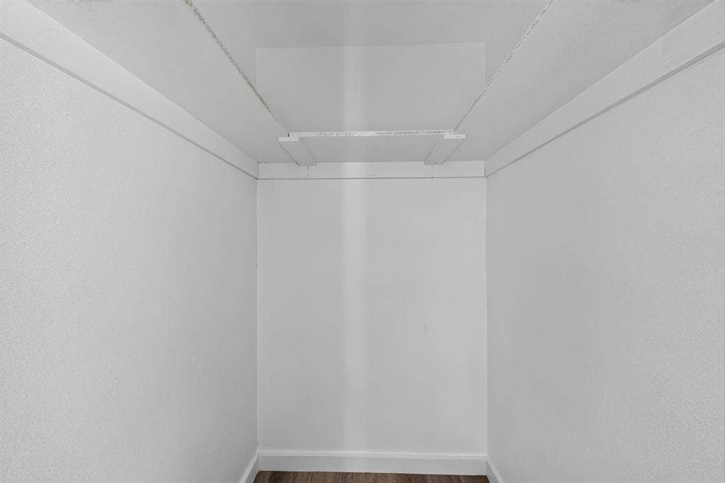 1831 Highland Street, Mesquite, TX 75149 Storage area featuring white walls, wood-finish flooring, and a built-in overhead shelf