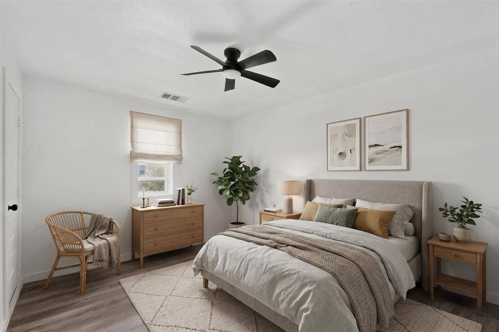 1831 Highland Street, Mesquite, TX 75149 Neutral-toned room featuring wood-finish flooring, a matte black multi-blade ceiling fan with integrated lighting, and a window with a fitted fabric roman shade
