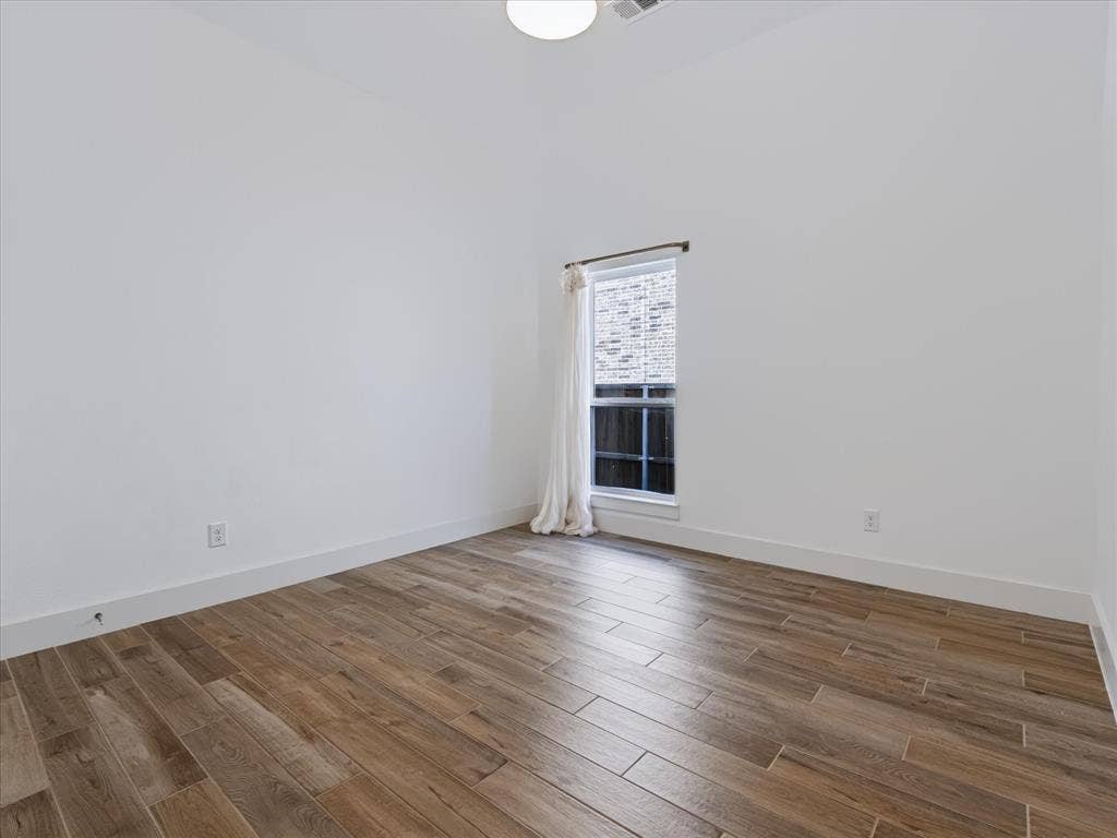 1103 Sandgate Drive, Forney, TX 75126 Interior room featuring wood-finish tile flooring, white walls, and a single window with a white frame