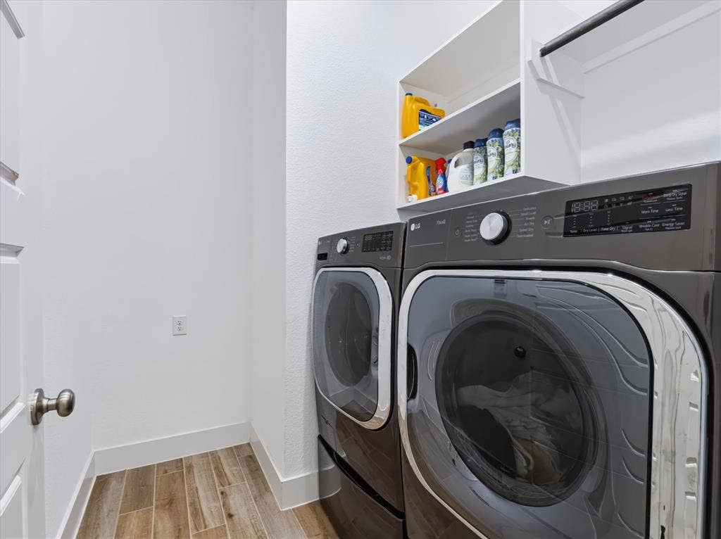 1103 Sandgate Drive, Forney, TX 75126 Laundry area featuring wood-finish tile flooring, built-in white overhead shelving, and a metal hanging rod