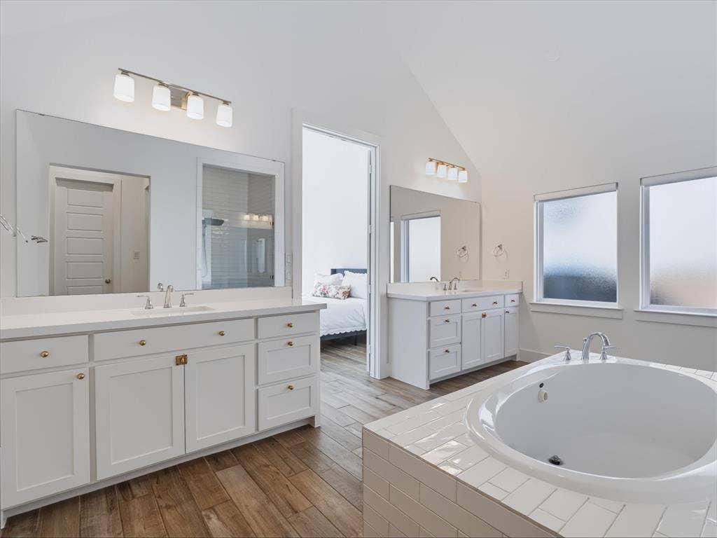1103 Sandgate Drive, Forney, TX 75126 Dual white vanities featuring shaker-style cabinetry, white countertops, and large wall-mounted mirrors