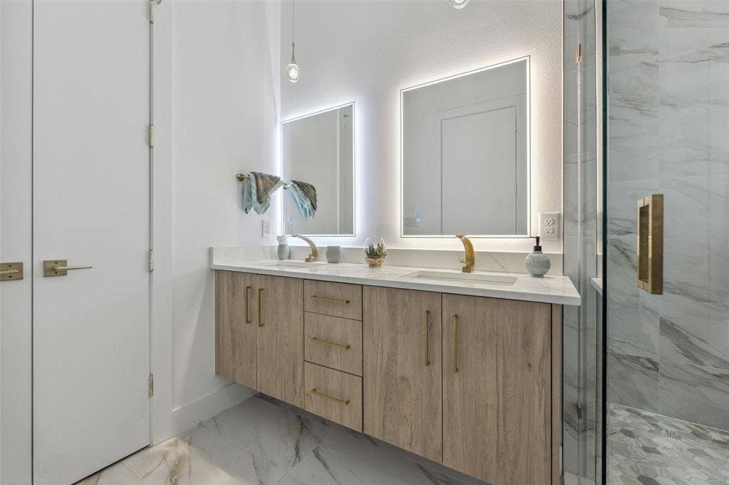 Bathroom featuring tile patterned floors, vanity, and a shower with shower door