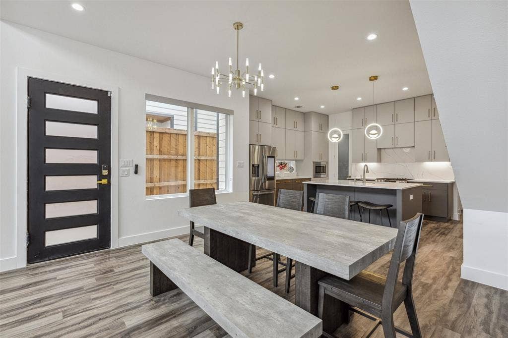 Dining room featuring hardwood / wood-style flooring, sink, and an inviting chandelier