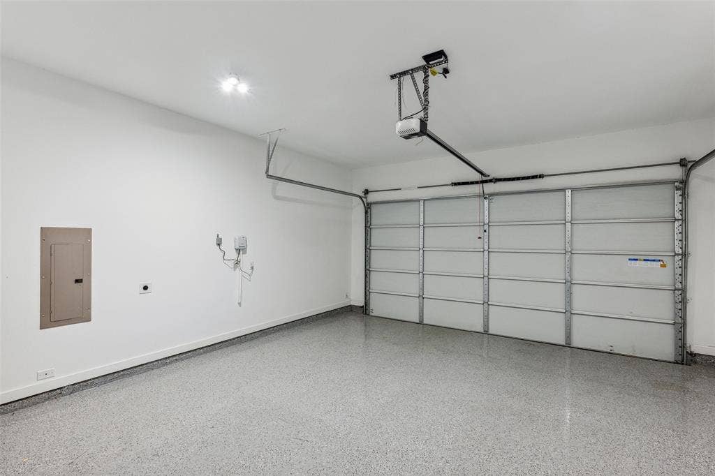 Garage featuring a garage door opener and electric panel