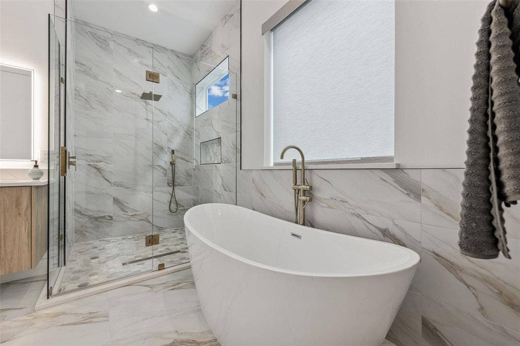 Bathroom with plus walk in shower, tile walls, tile patterned flooring, and vanity