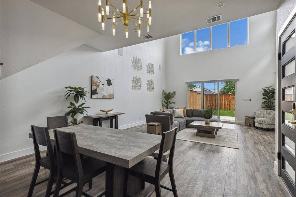 Dining space featuring a high ceiling, a chandelier, and wood-type flooring