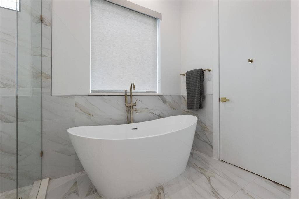 Bathroom with plus walk in shower, tile patterned flooring, and tile walls