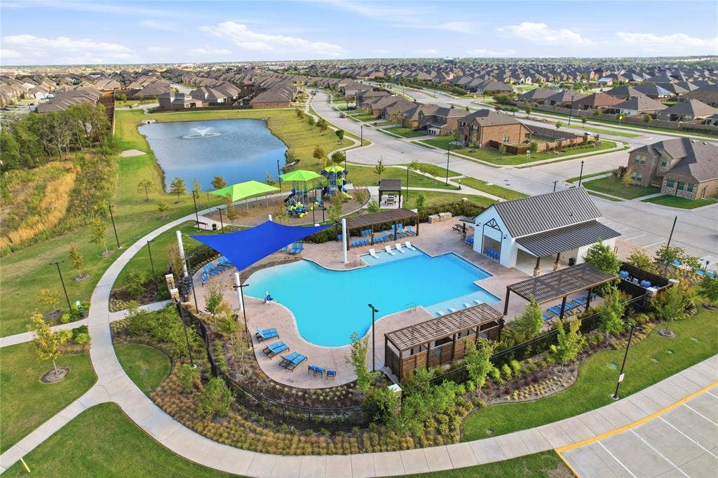 1108 Emerald Gate Drive, Princeton, TX 75407 Community amenity complex featuring an expansive swimming pool, multiple shaded pergola structures, a dedicated playground, and a pond with a central fountain