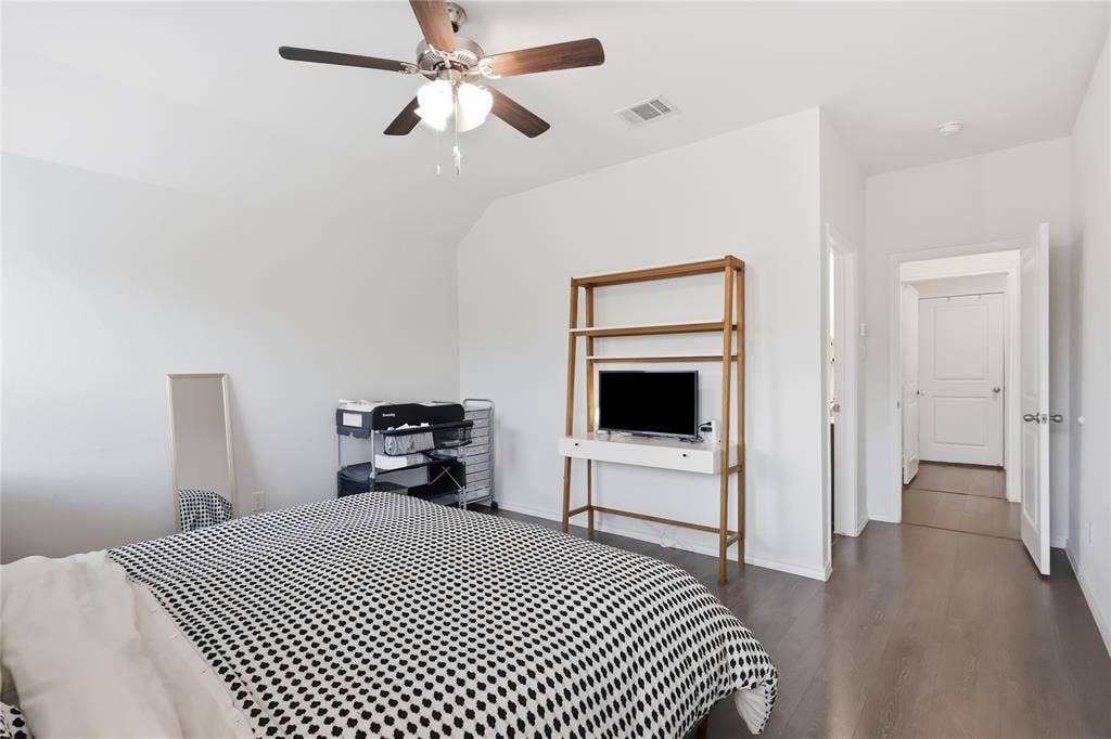 1108 Emerald Gate Drive, Princeton, TX 75407 Neutral interior featuring wood-finish flooring, white walls, vaulted ceiling, and a ceiling-mounted light fixture with a fan
