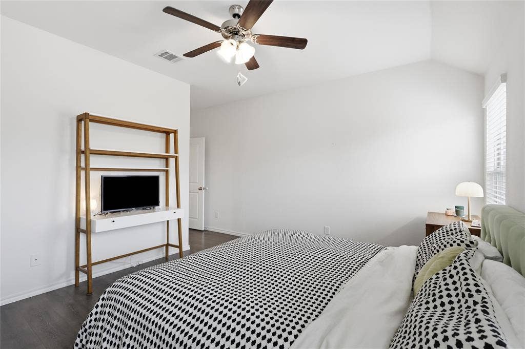 1108 Emerald Gate Drive, Princeton, TX 75407 Vaulted ceiling featuring a central multi-blade ceiling fan with integrated lighting, wood-finish flooring, and window blinds