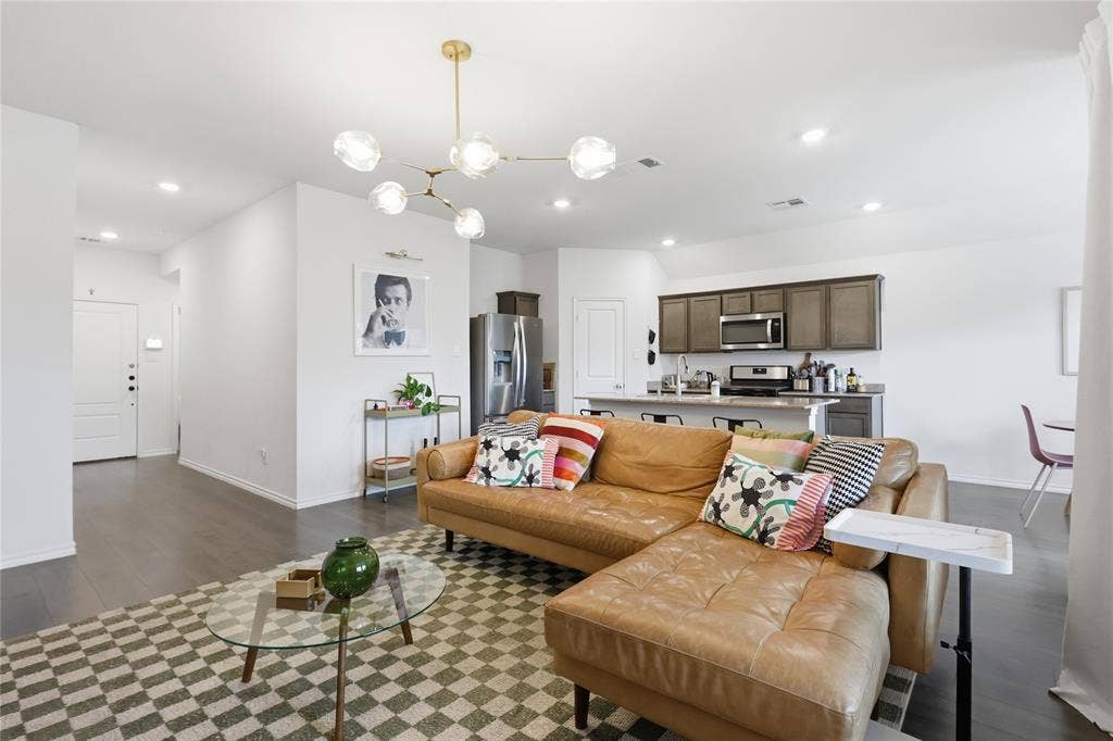 1108 Emerald Gate Drive, Princeton, TX 75407 Open-concept interior featuring wood-finish flooring, a modern multi-globe chandelier, an island kitchen with stone countertops, and recessed lighting