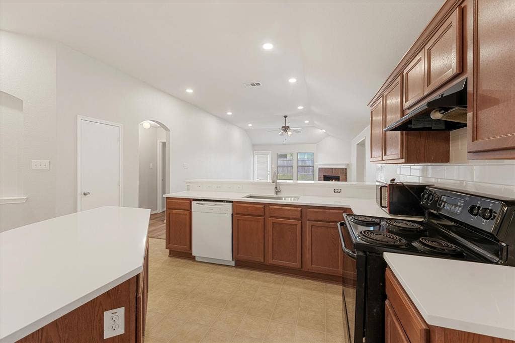 2004 Athabasca Falls Drive, Anna, TX 75409 Kitchen featuring wood cabinetry, white countertops, recessed ceiling lighting, a stainless steel sink, and a black range