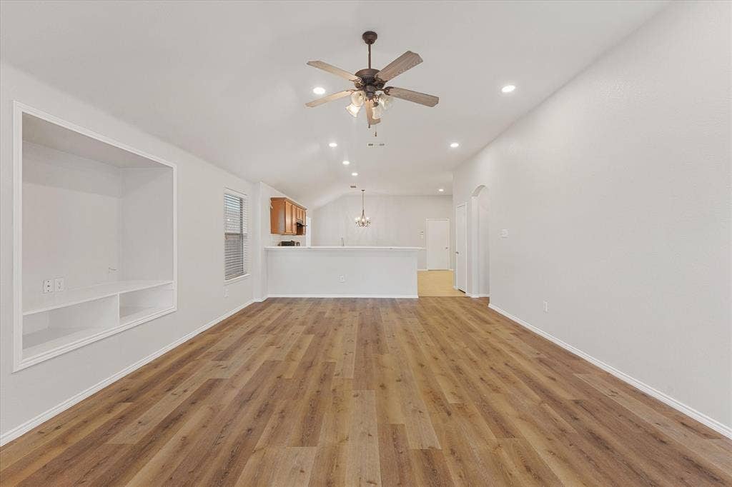 2004 Athabasca Falls Drive, Anna, TX 75409 Open-concept interior featuring wood-finish flooring, vaulted ceilings, recessed lighting, a ceiling fan, and built-in shelving