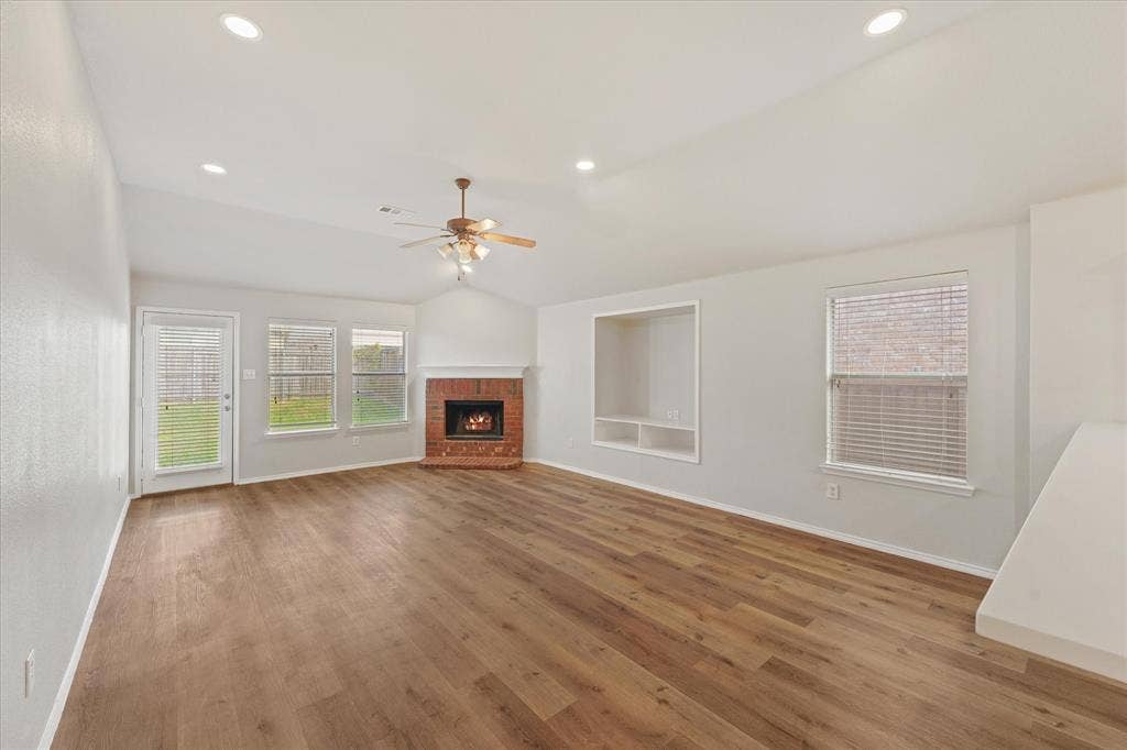 2004 Athabasca Falls Drive, Anna, TX 75409 Vaulted ceilings featuring recessed lighting, wood-finish flooring, a brick fireplace, built-in shelving, and a ceiling fan