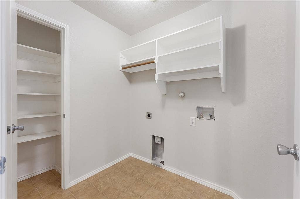 2004 Athabasca Falls Drive, Anna, TX 75409 Utility space featuring ceramic tile flooring, built-in white shelving, and dual-level open storage