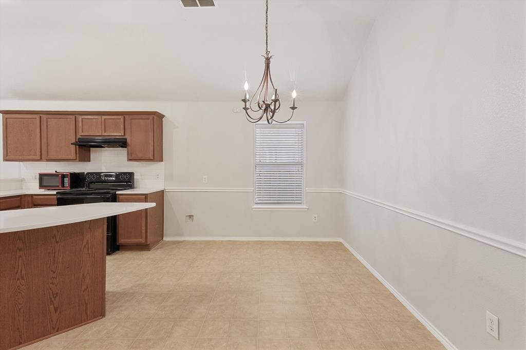 2004 Athabasca Falls Drive, Anna, TX 75409 Vaulted ceiling, wood-finish cabinetry, central chandelier lighting, and decorative wall molding