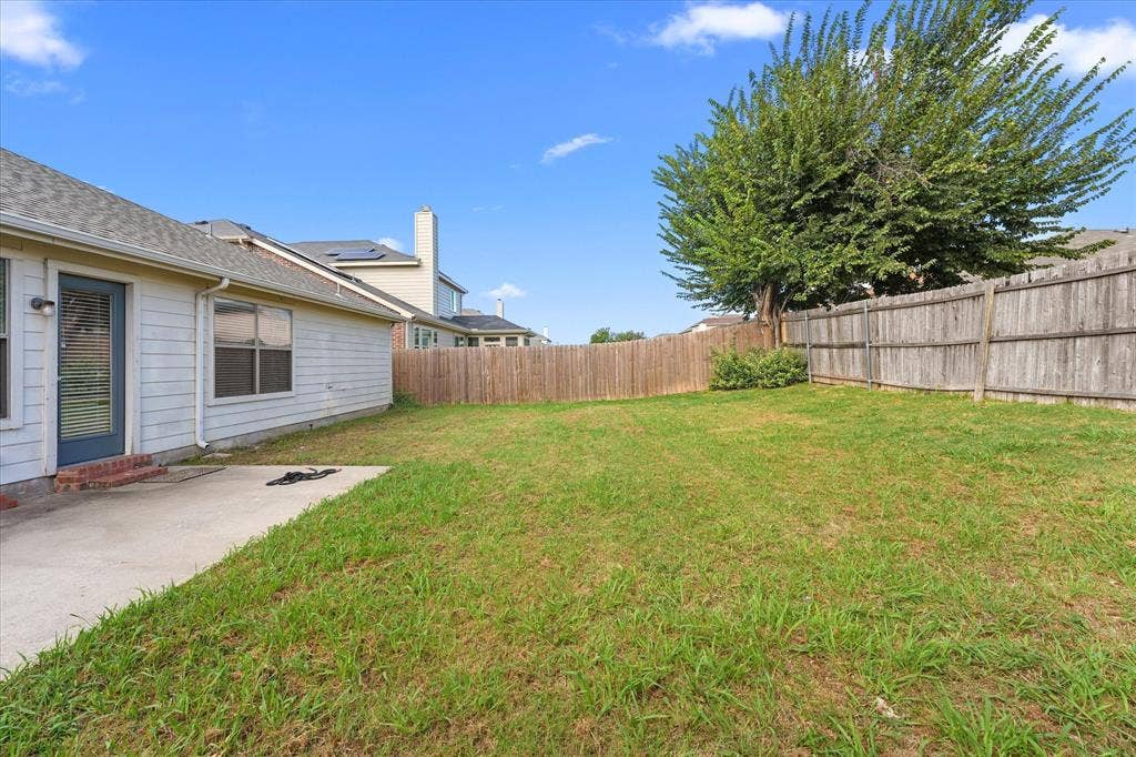 2004 Athabasca Falls Drive, Anna, TX 75409 Backyard featuring a concrete patio, wood privacy fencing, and a mature tree