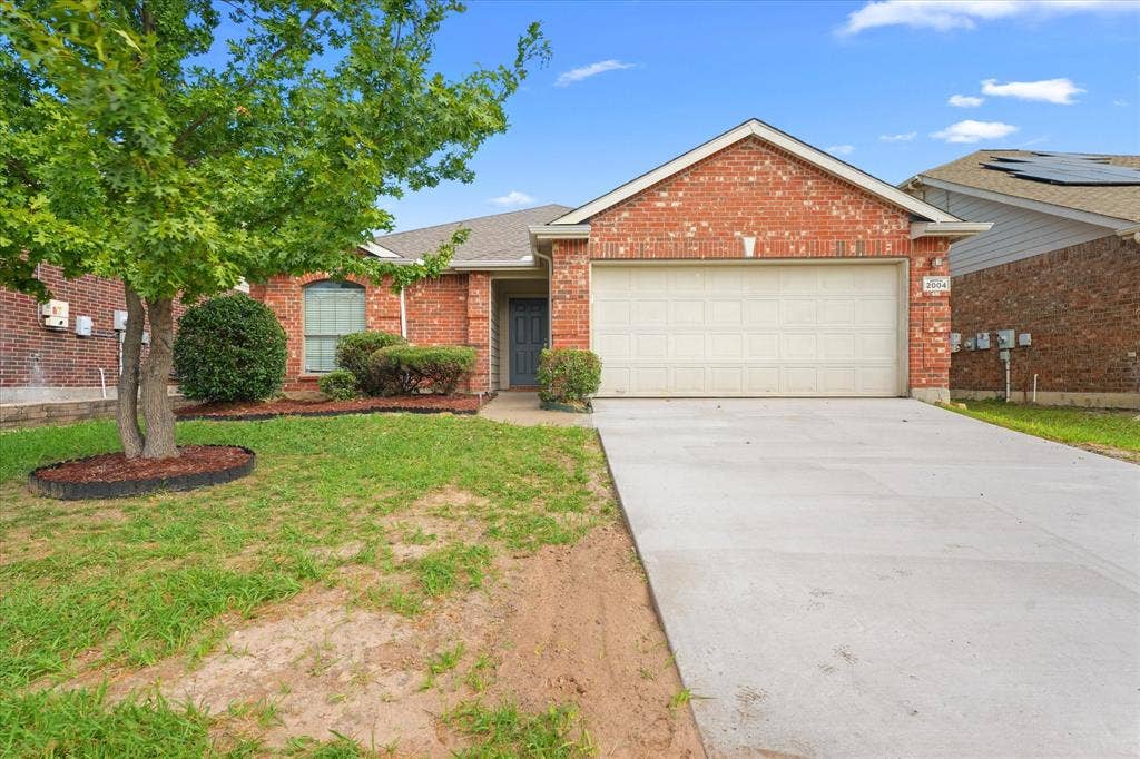 2004 Athabasca Falls Drive, Anna, TX 75409 Brick exterior featuring a gabled roofline, concrete driveway, and attached two-car garage