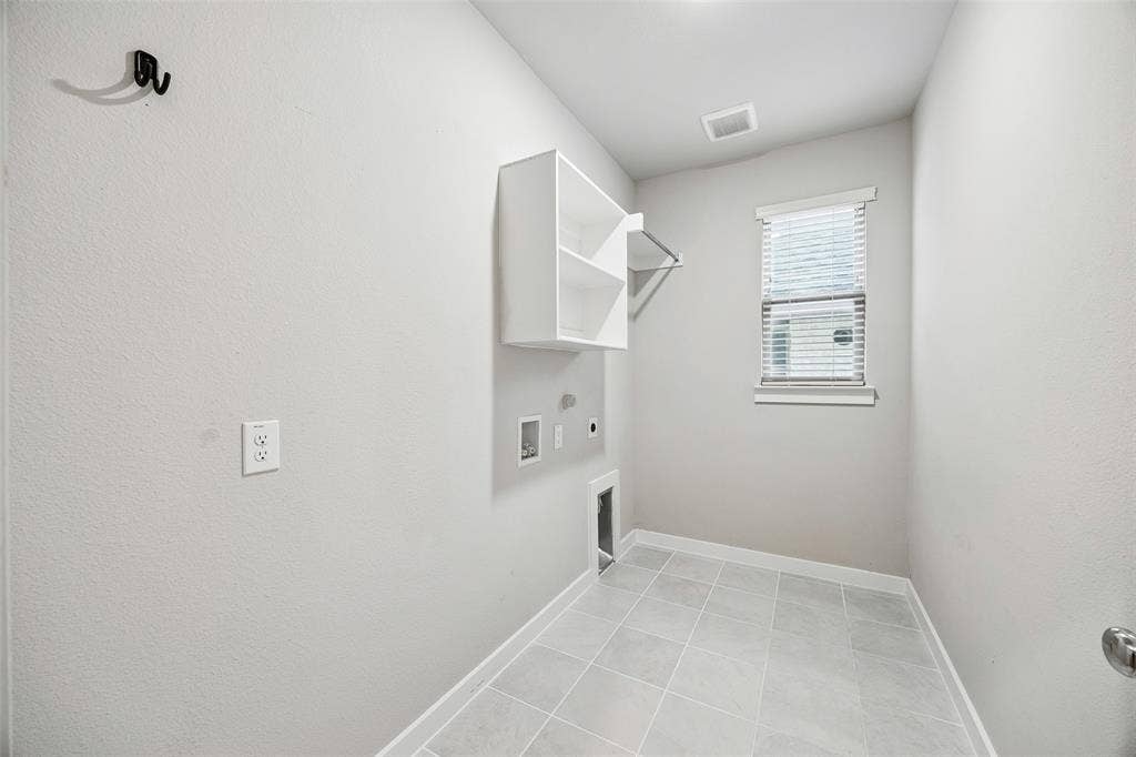 Utility room featuring large-format ceramic tile flooring, built-in shelving, a metal hanging rod, and a single-hung window with horizontal blinds