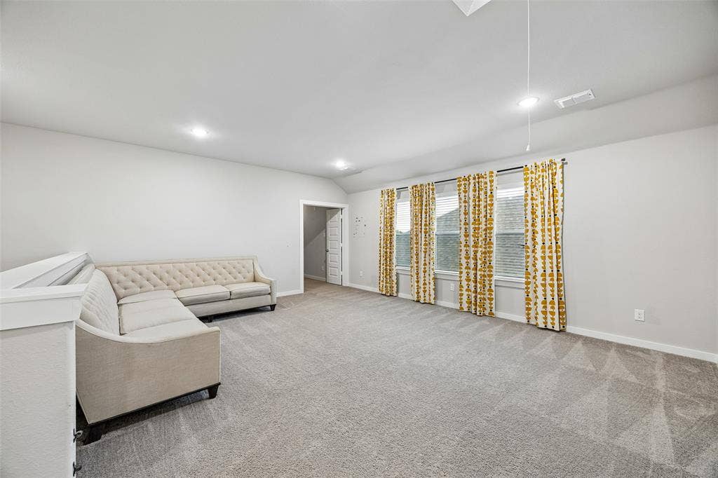 Expansive room featuring neutral wall tones, wall-to-wall carpeting, recessed ceiling lighting, and multiple windows