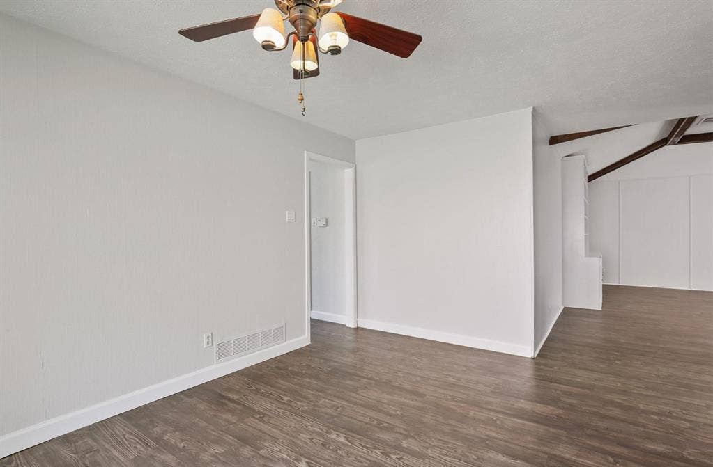 9712 Summerhill Lane, Dallas, TX 75238 Wood-finish flooring, neutral wall tones, multi-light ceiling fan, and exposed structural ceiling beams