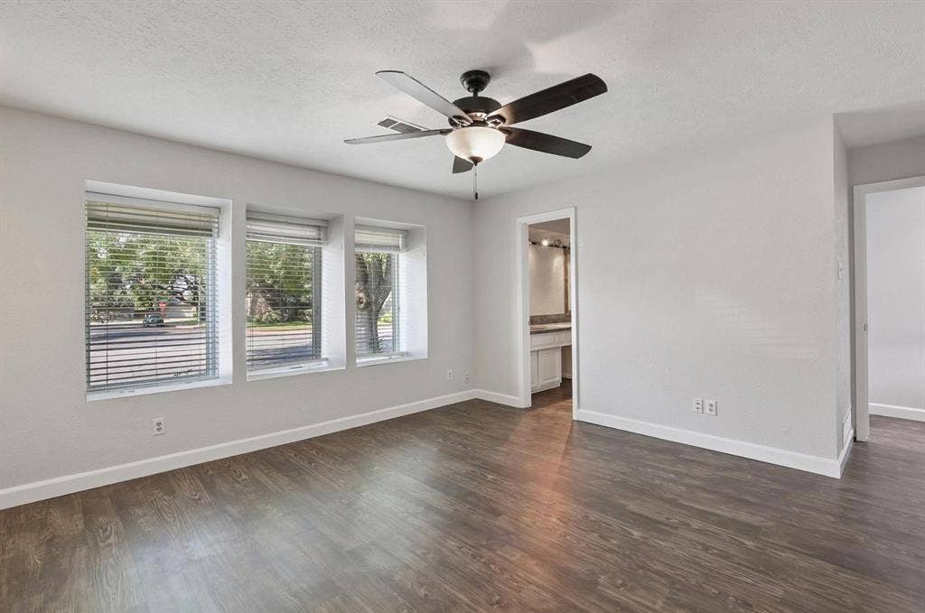 9712 Summerhill Lane, Dallas, TX 75238 Wood-finish flooring, triple-pane window configuration, and a central ceiling fan with integrated lighting